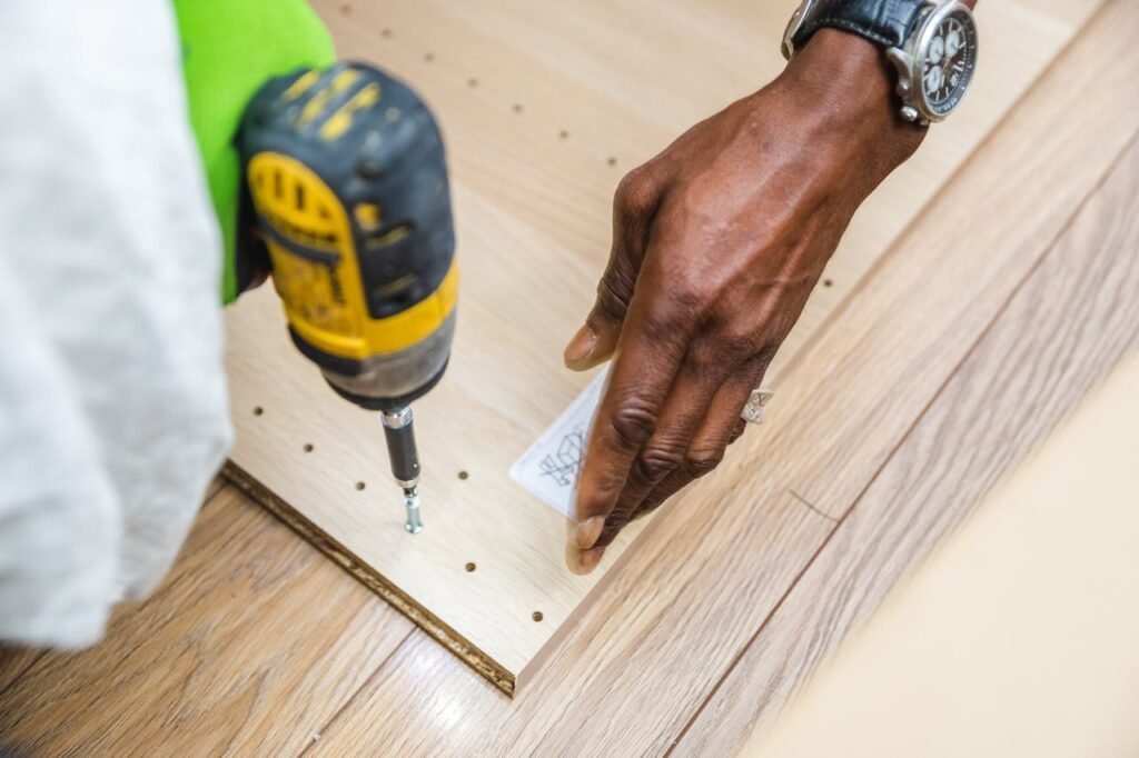 A close-up view of a craftsperson using a drill on a wooden board, showcasing precise carpentry work.